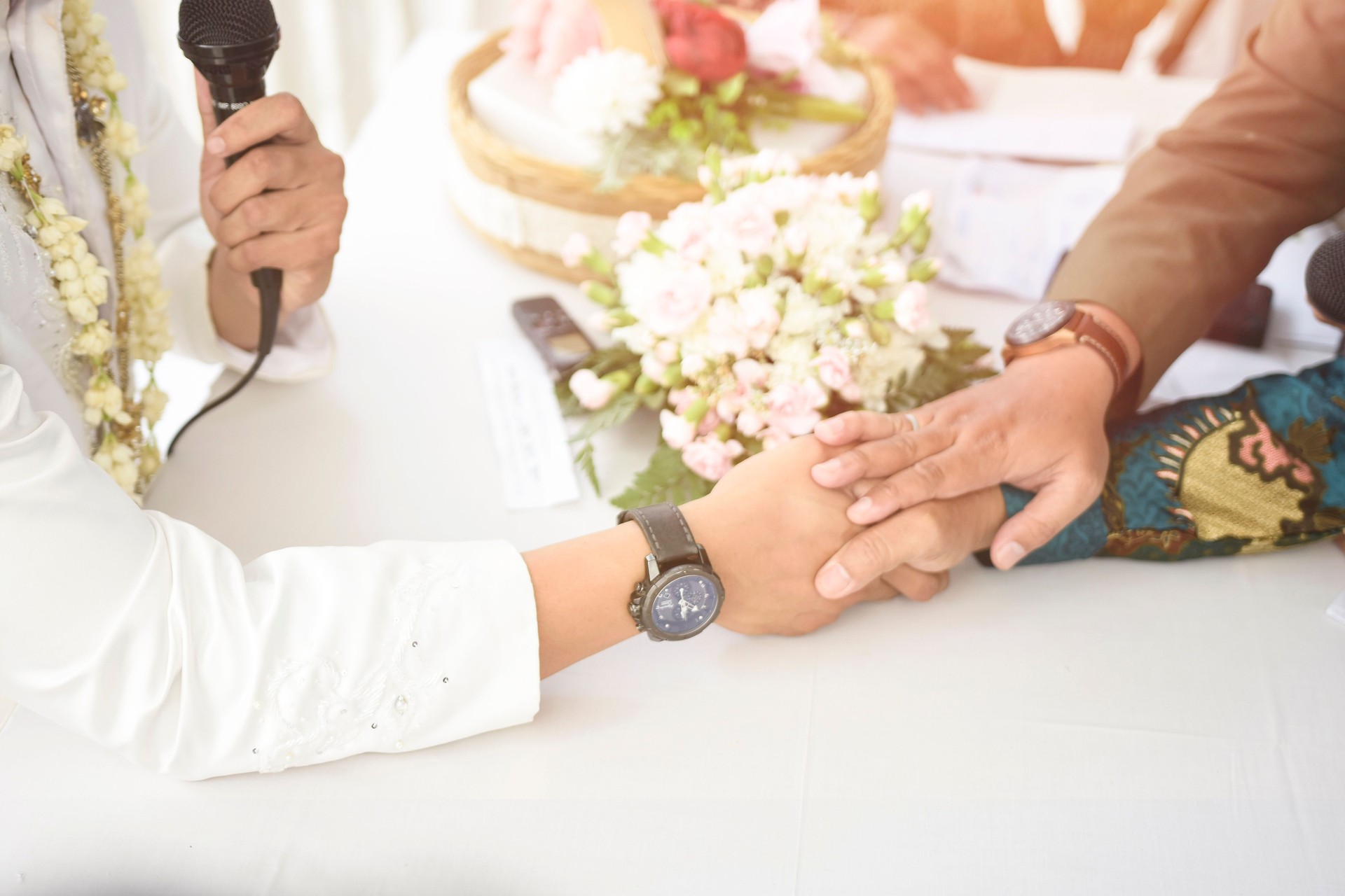 Marriage consent, the groom performs 'ijab kabul' with the bride's father, close up shot of shaking hands during the marriage consent